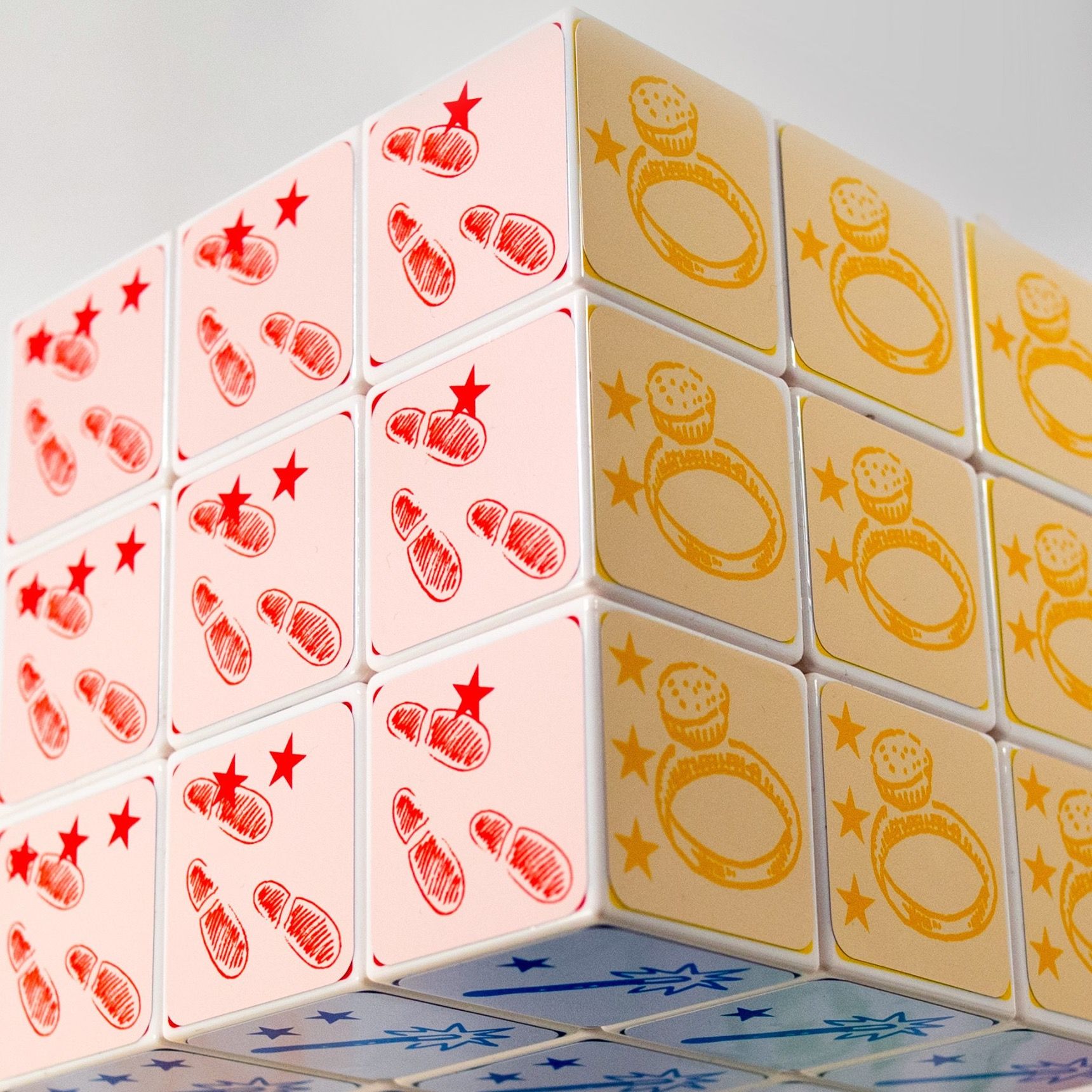 Gros plan sur le cube Cubification : faces rouge et jaune, icônes dessinées à la main.