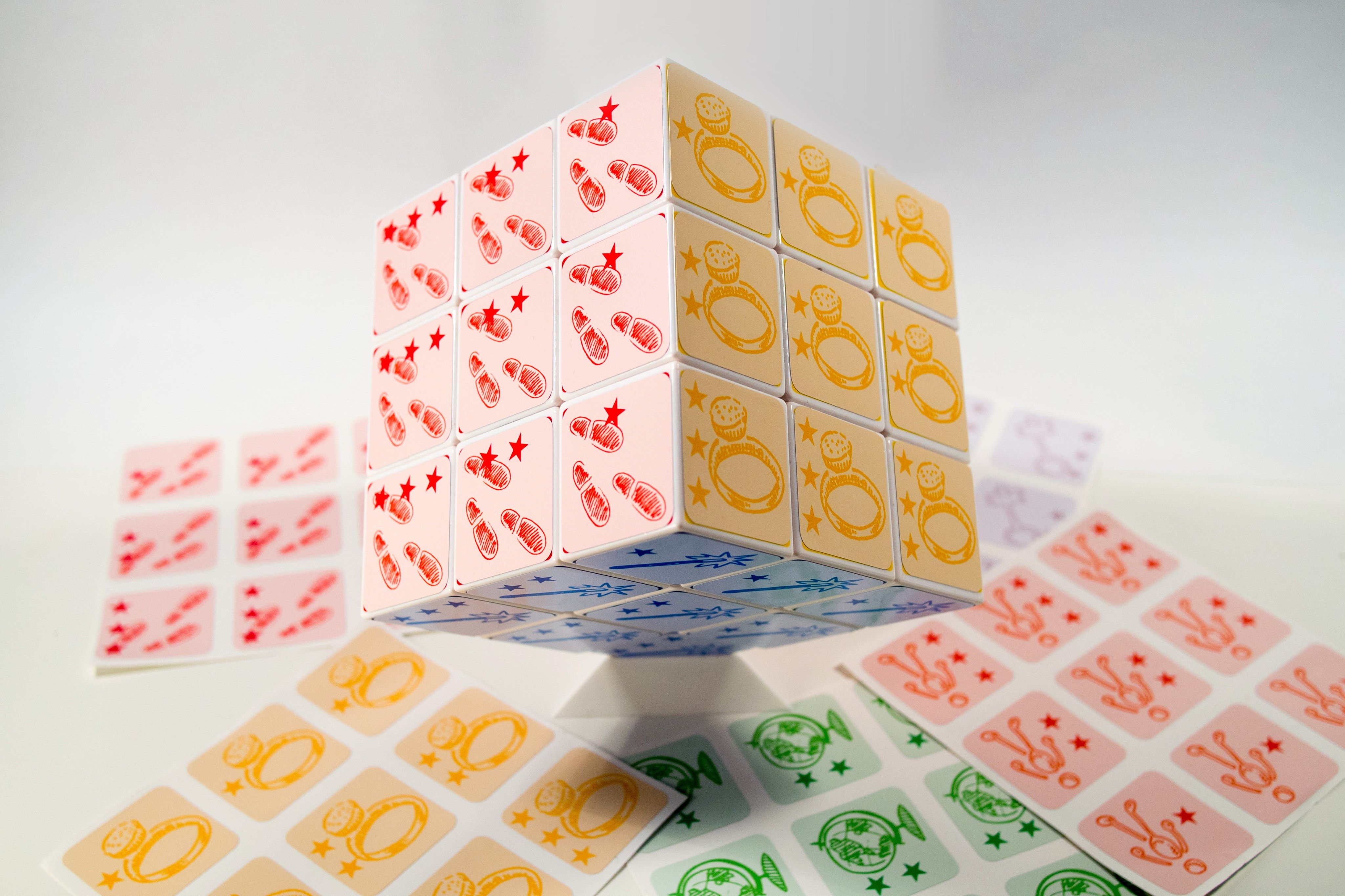 Le cube Cubification géant sur son socle, entouré de planches de stickers.